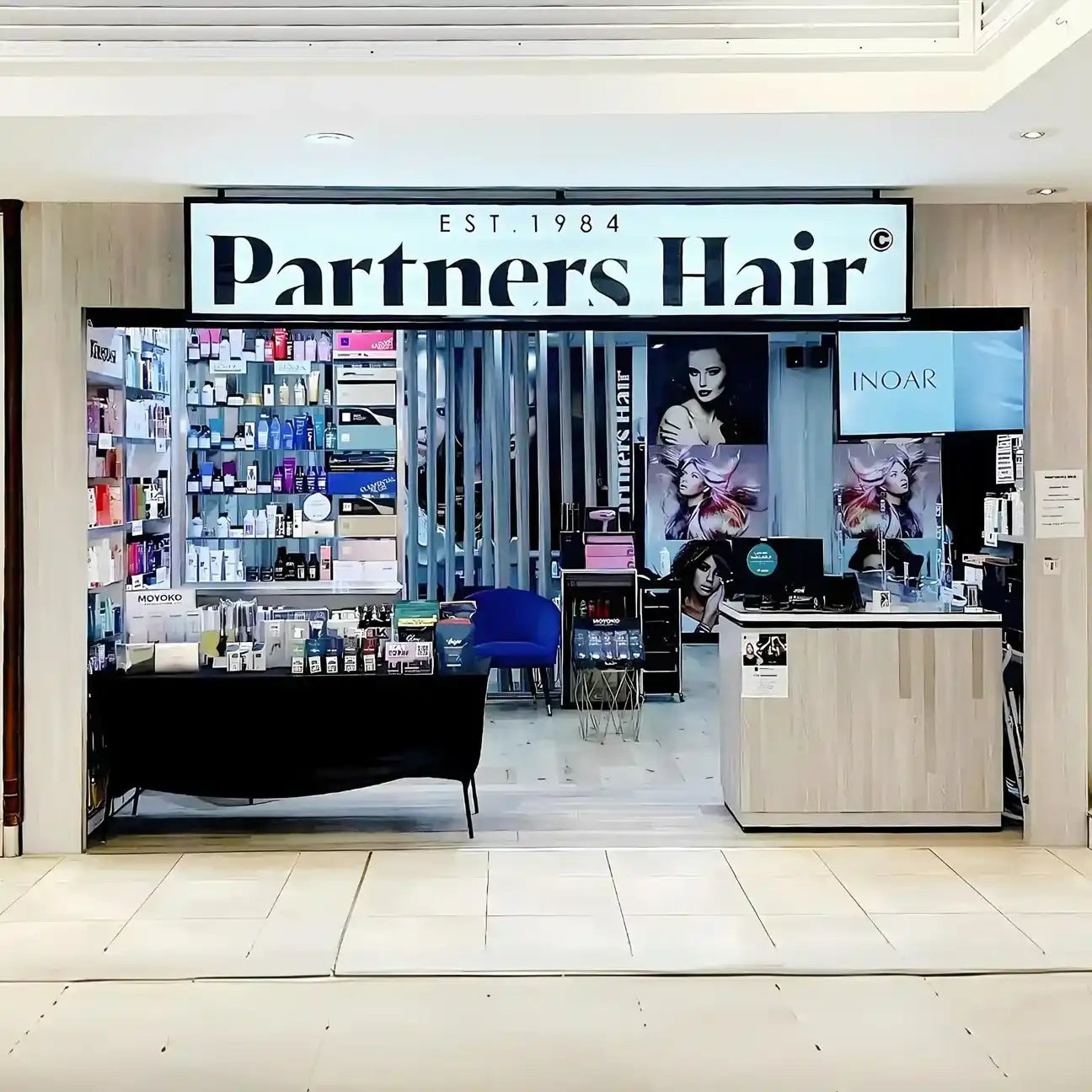 Partners Hair salon storefront with product displays and signage.