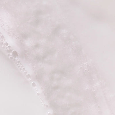 Pureology Pure Volume: Close-up of white bubbly texture, showcasing hair volume effect.