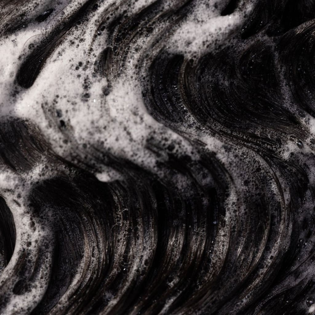 Swirling black and white foam from Pureology Smooth Perfection Shampoo for color-treated hair