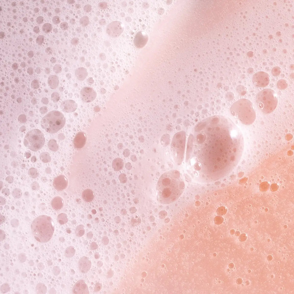 Frothy pink soap bubbles from Pureology Strength Cure Shampoo, perfect for color-treated hair