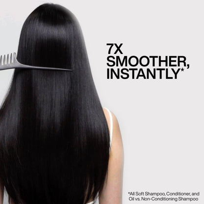 Combing long, shiny black hair with Redken All Soft Argan Oil for smooth, nourished locks