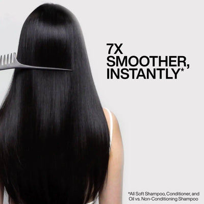 Combing long, shiny black hair with Redken All Soft Argan Oil for smooth, nourished locks