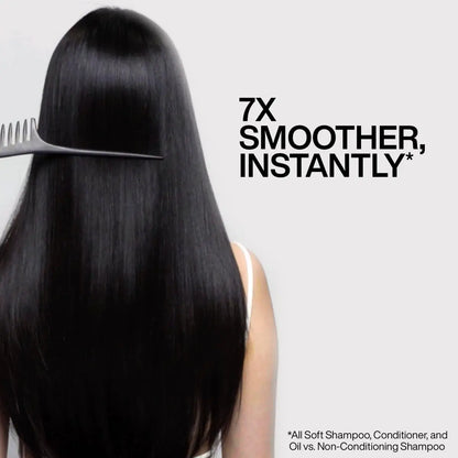 Combing long, shiny black hair with Redken All Soft Argan Oil for smooth, nourished locks