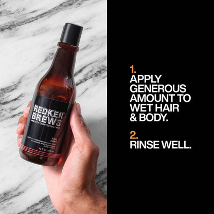 Bottle of Redken Brews 3 In 1 Shampoo, Conditioner & Body Wash held in hand