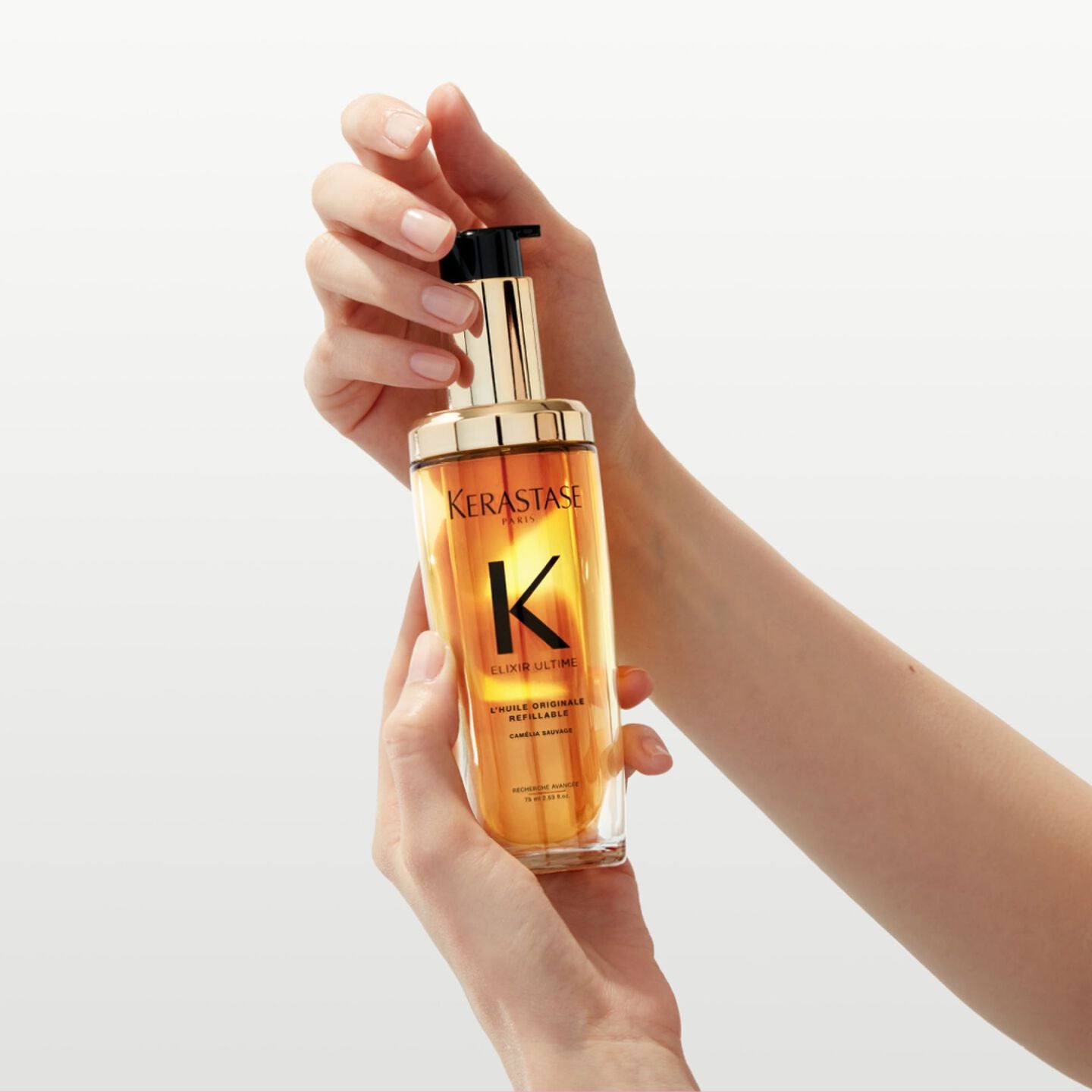 Kérastase Elixir Ultime: Refillable hair oil held in hand, Camellia Sauvage for shine and nourishment