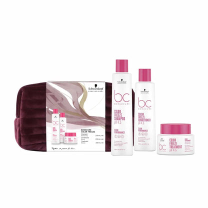 Hair care product set with pink and white bottles and a purple cosmetic bag.