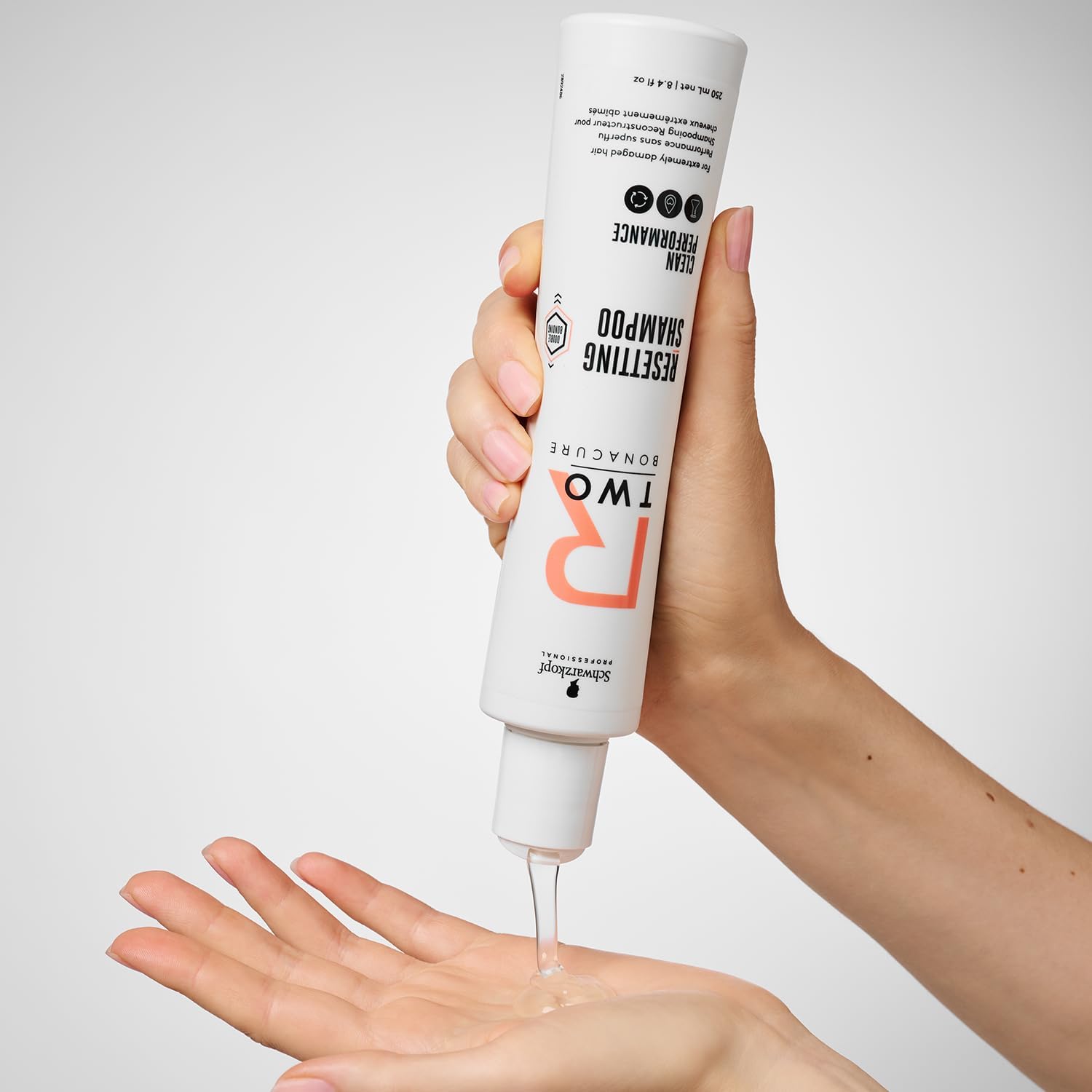 Schwarzkopf R-Two Resetting Shampoo 250ml being poured into a hand, ideal for restoring extremely damaged hair.