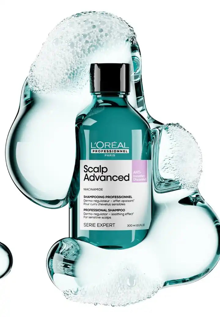 Teal bottle of L’Oreal Scalp Advanced hair product surrounded by water splashes.