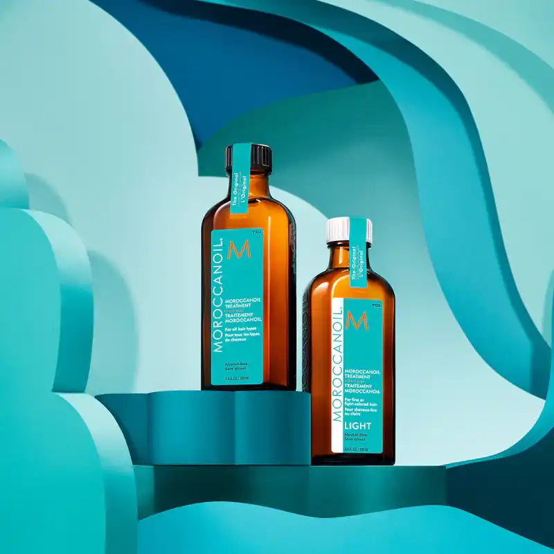 Two amber glass bottles of Moroccanoil hair treatment.