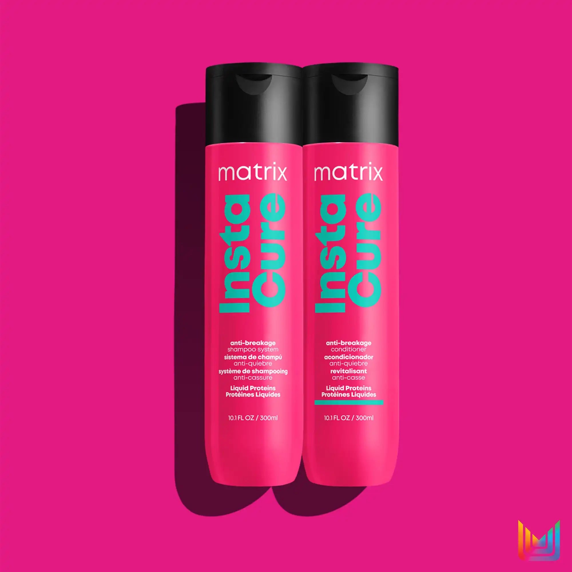 Two pink and black bottles of Matrix brand hair product.