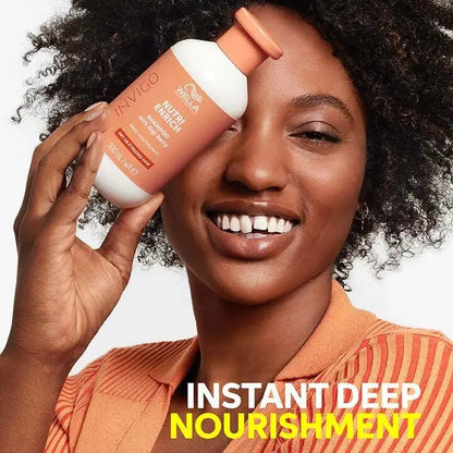 A bottle of hair care product held next to a smiling woman with curly hair.