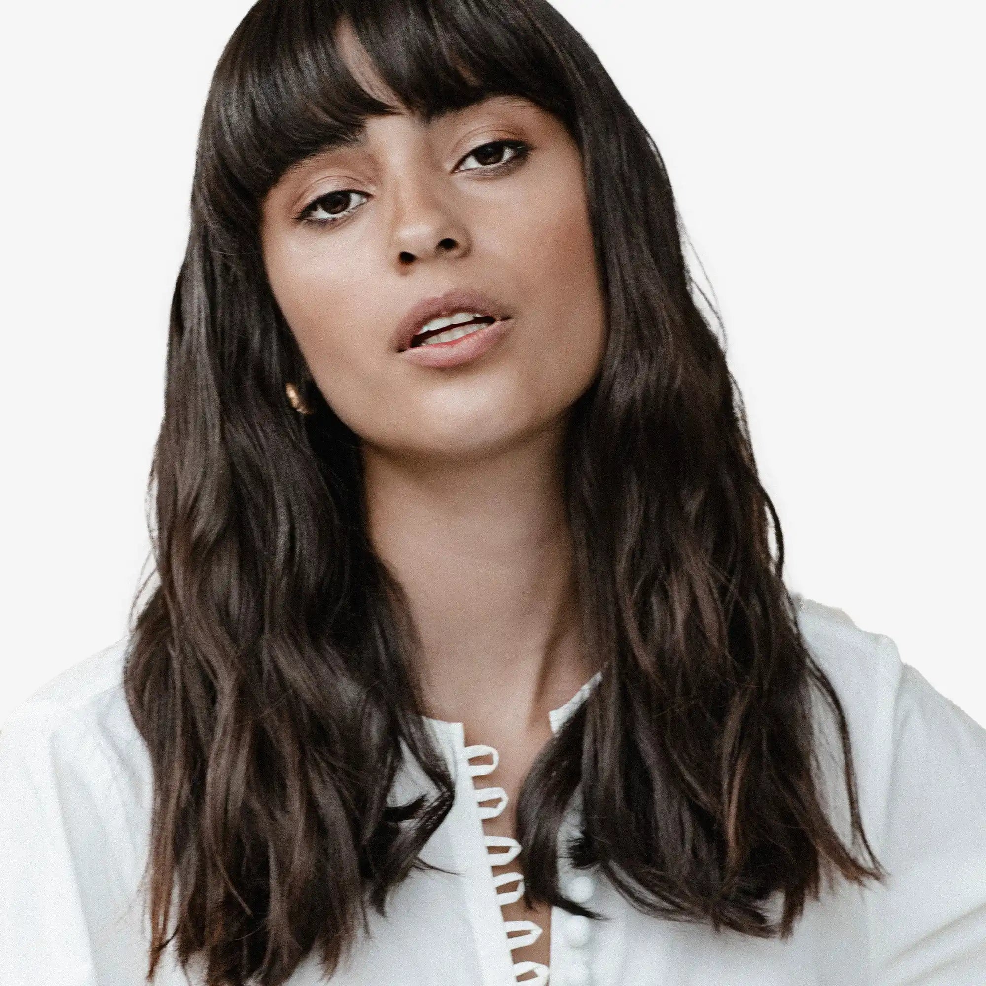 Woman with long dark hair and bangs wearing a white top.