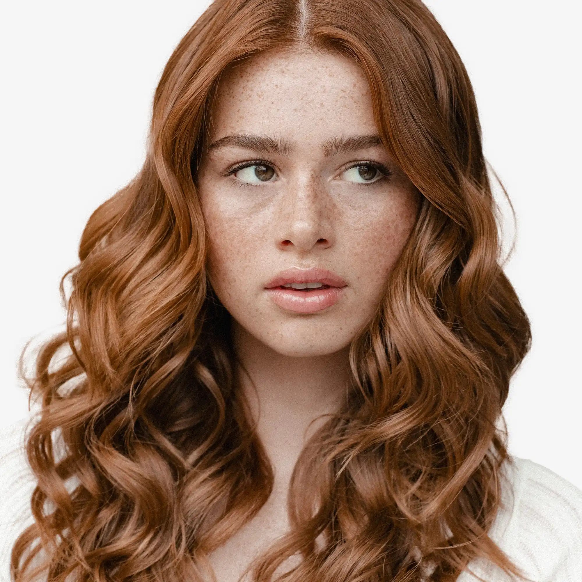 Young woman with long, wavy auburn hair and freckles.